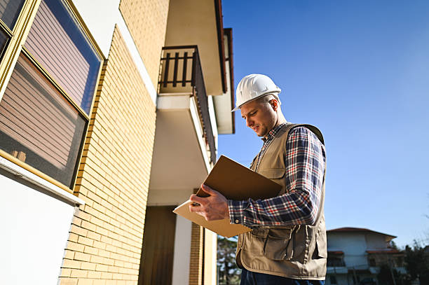 Property manager reviewing a vacant property security inspection checklist outside a commercial building